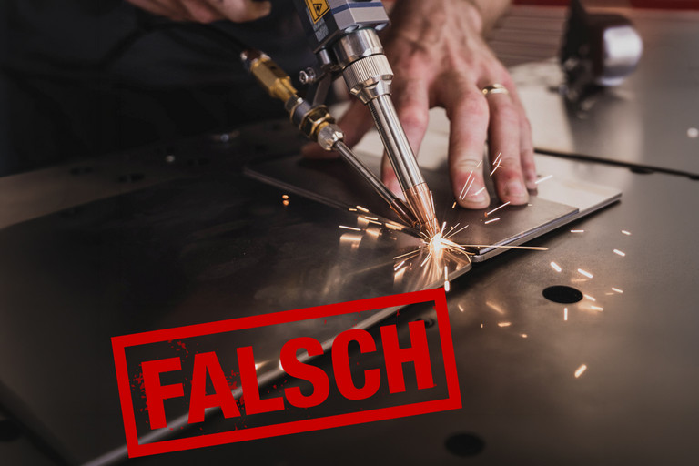 Eine Person führt Schweißarbeiten an einem Metallbauteil auf einer Werkbank aus. Im Vordergrund ist der rote Schriftzug „FALSCH“ zu sehen, die Person trägt keine erkennbaren Schutzhandschuhe.
