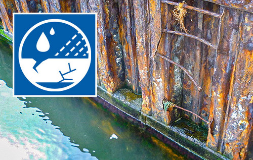 Stark korrodierte Stahlwand im Wasserbereich mit deutlichen Rostspuren und Abplatzungen. Links oben Logo Erfahrungsaustausch Korrosionsschutz