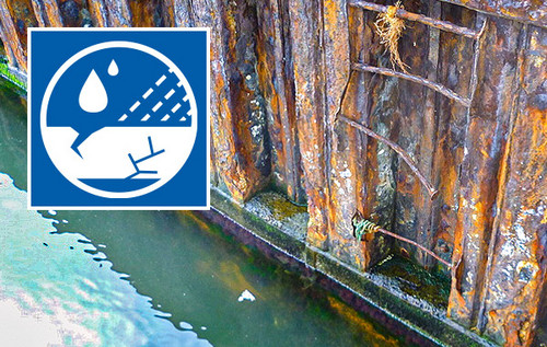 Stark korrodierte Stahlwand im Wasserbereich mit deutlichen Rostspuren und Abplatzungen. Links oben Logo Erfahrungsaustausch Korrosionsschutz