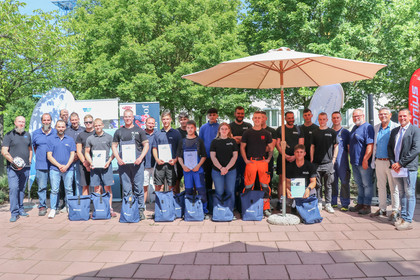 Gruppenfoto mit Betreuern beim Wettbewerb „Jugend schweißt“ 2025 im Außenbereich der SLV Halle GmbH, ausgezeichnete Teilnehmende halten Urkunden in den Händen