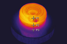 Thermografieaufnahme eines zylindrischen additiv gefertigten Bauteils mit spiralförmigem Aufbau, die Temperaturverteilung ist farblich dargestellt; drei Messpunkte (P1, P2, P3) markieren unterschiedliche Zonen.