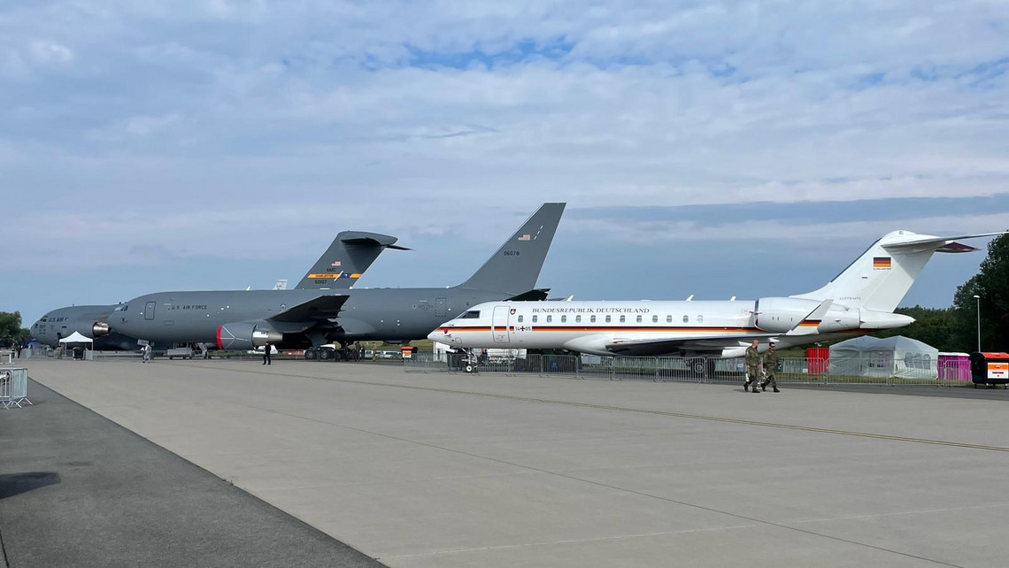 Drei Militärflugzeuge unterschiedlicher Größe stehen nebeneinander auf dem Rollfeld, im Vordergrund ein weißes Flugzeug der Luftwaffe, dahinter zwei graue Maschinen der U.S. Air Force