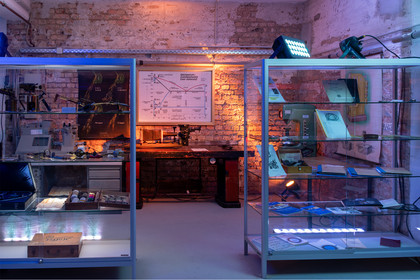 Ein Ausstellungsraum mit beleuchteten Vitrinen, historischen Messgeräten, Diagrammen und Schautafeln zeigt die technische Entwicklung der Schweiß- und Werkstoffprüfung.