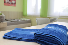 Nahaufnahme von zwei blauen Handtüchern mit dem Logo der SLV Halle auf einem Tisch in einem Einzelzimmer des Lerninternats.