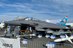 Eurofighter Typhoon der Bundeswehr mit aufgestellten Raketenmodellen und Infotafeln, präsentiert auf einer Flugmesse vor dem Airbus-Ausstellungszelt.