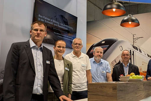 Das Team aus fünf Personen posiert vor dem Stand.