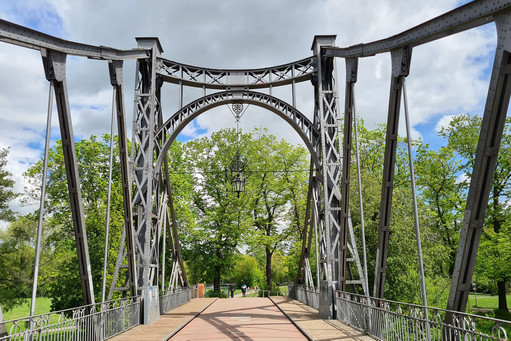 Altstahlbrücke: Blickwinkel von der Mitte der Brücke, dahinter viele grüne Bäume
